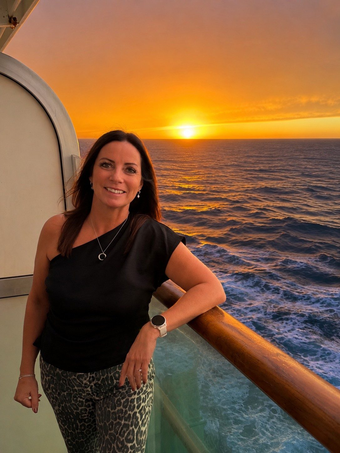Annette Pearce on a cruise ship balcony at sunset